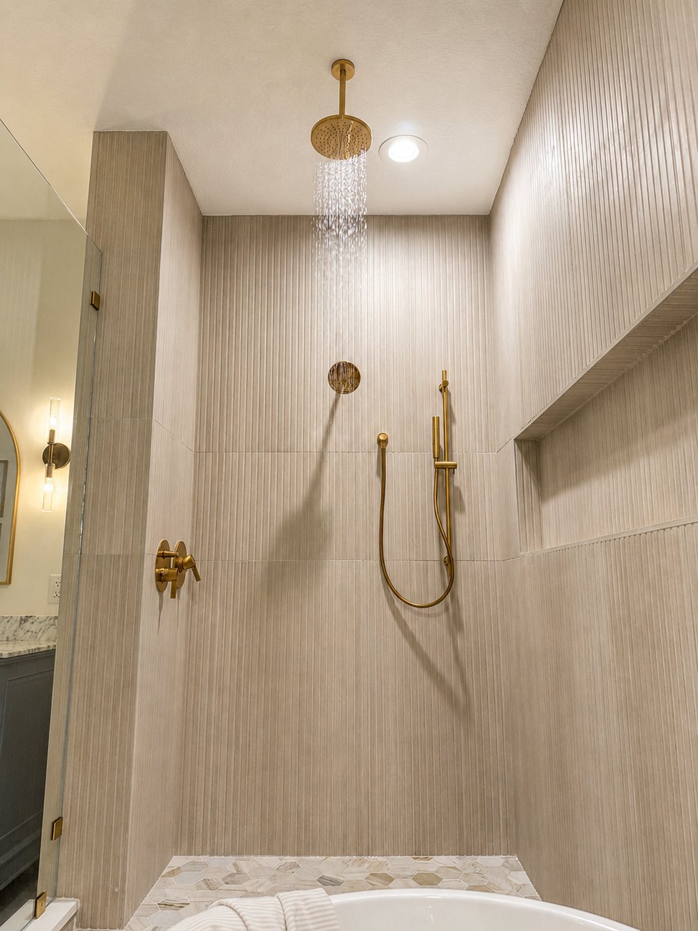 Fluted tile shower with gold fixtures